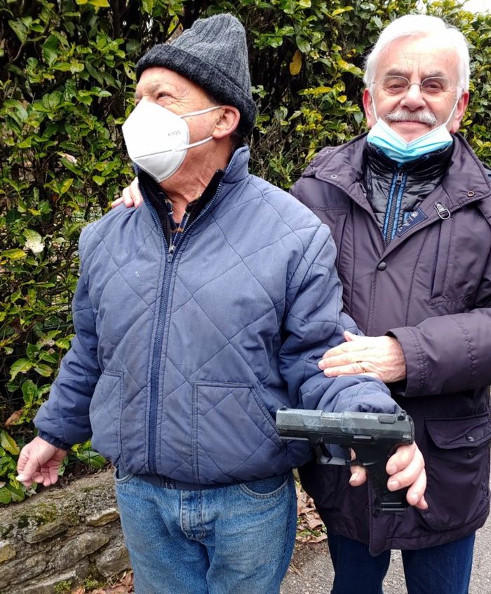 Biagio Locatelli mentre tiene la pistola trovata nel greto del fiume; dietro Silvio Riva
