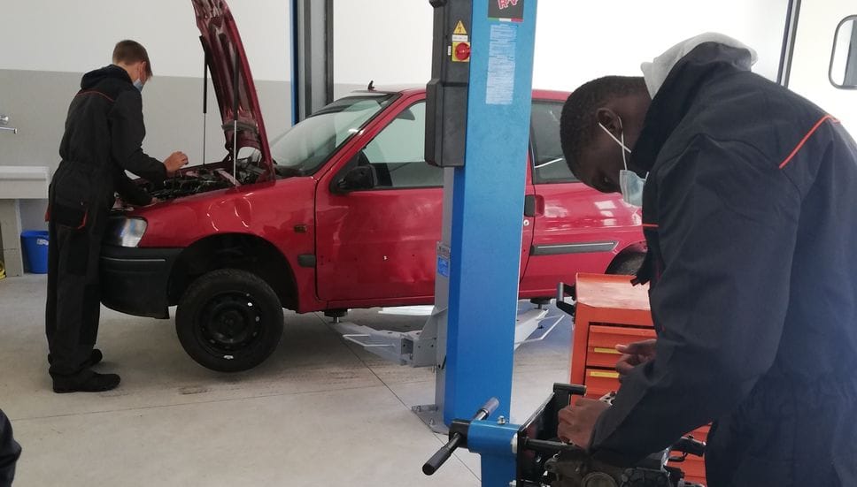 Giovani in un’officina meccanica per la formazione professionale in una foto d’archivio Giovani in un’officina meccanica per la formazione professionale in una foto d’archivio