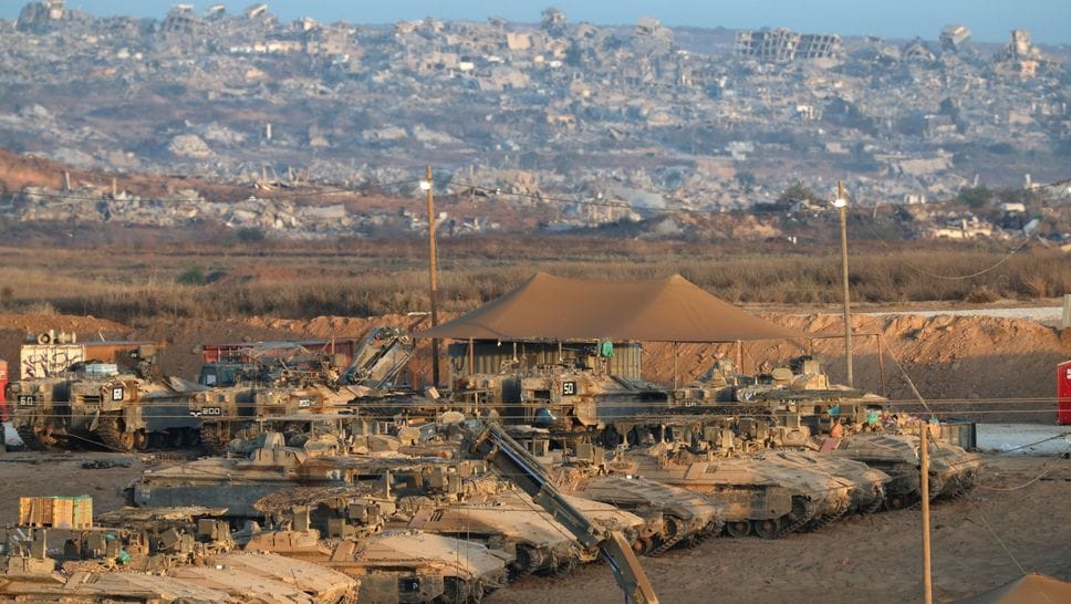 Carri armati israeliani vicino al confine con la Striscia di Gaza, le macerie sullo sfondo