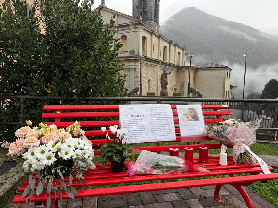 La panchina rossa a pochi metri dalla chiesa parrocchiale di Strozza, diventato luogo spontaneo di riflessione e di preghiera dopo l’uccisione di Pamela Genini