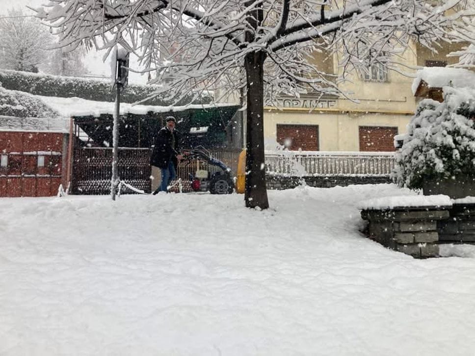 Il sindaco di Berbenno, Manuel Locatelli, spala un marciapiedi