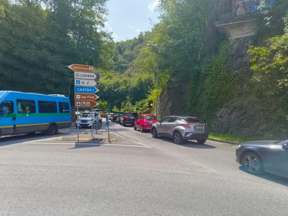 Traffico su via Nazionale da e verso la litoranea. La rotonda porta allo svincolo per la Statale 42 e le gallerie, chiuse in direzione Costa Volpino