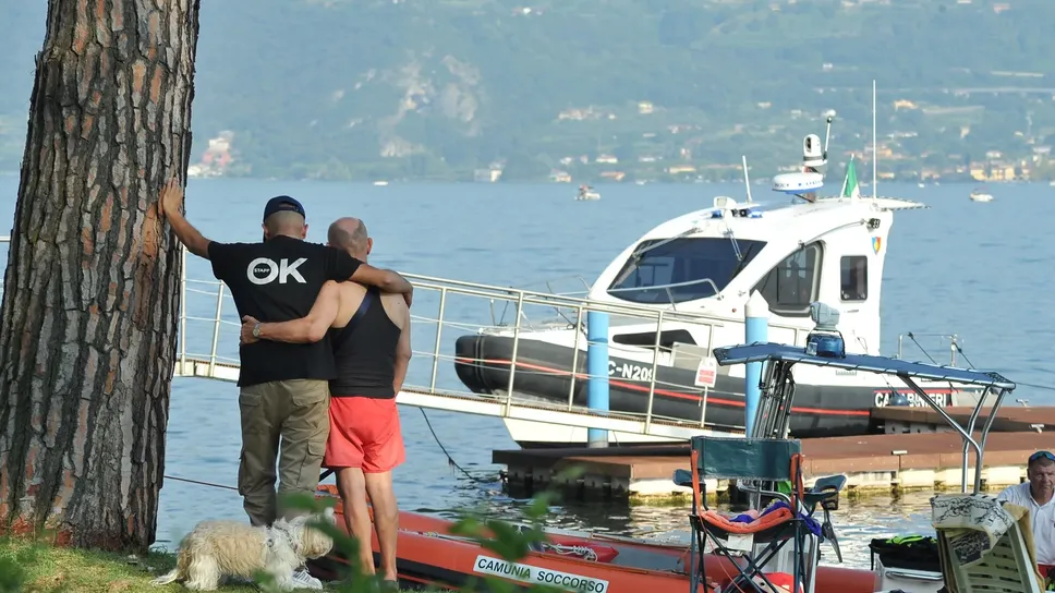 Il figlio (con la maglietta nera con la scritta «OK») abbraccia il padre