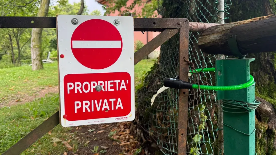 Il passaggio chiuso con cancello e lucchetto Il passaggio chiuso con cancello e lucchetto