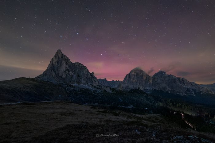 Un'aurora boreale colora di rosso il cielo delle Dolomiti