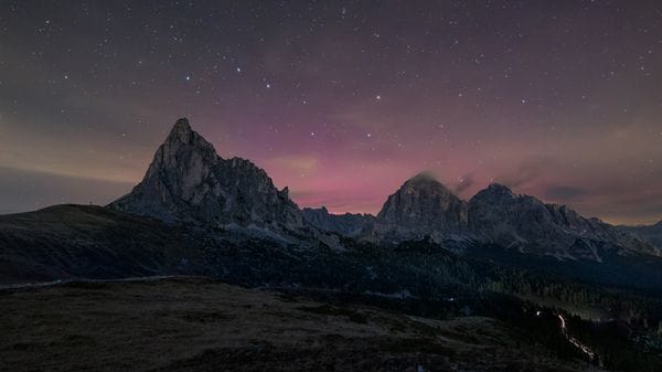 Un'aurora boreale colora di rosso il cielo delle Dolomiti