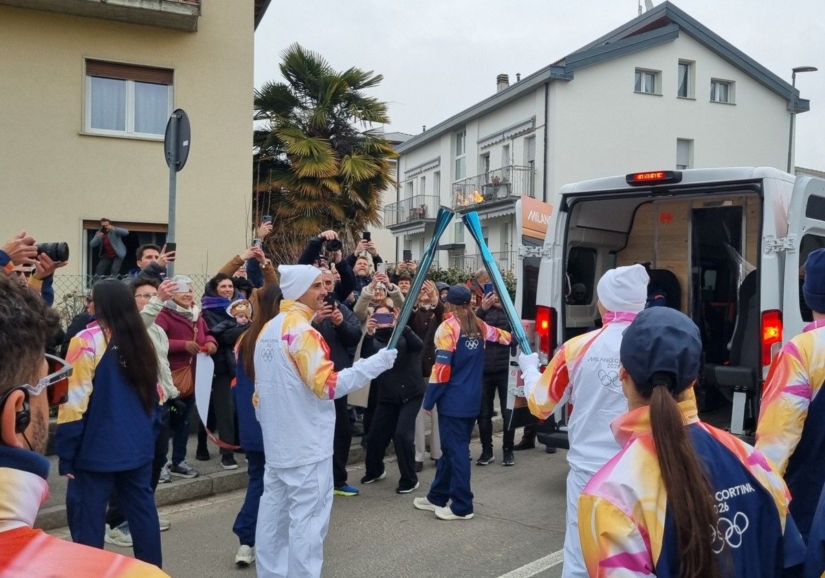 Il passaggio della fiamma olimpica tra due tedofori ad Almè