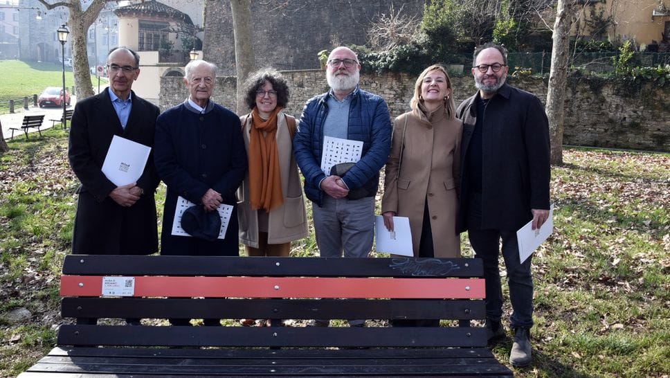 La presentazione di una delle panchine lungo il percorso con un’asta arancione e una targa con QR