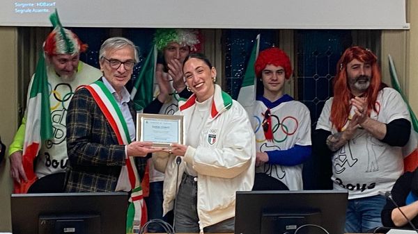 Il sindaco Alberto Locatelli premia Sara Conti, sullo sfondo i coloriti tifosi della pattinatrice