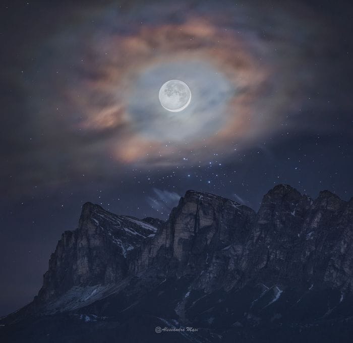 Un'aureola di nuvole per la Luna sopra le cime delle Dolomiti