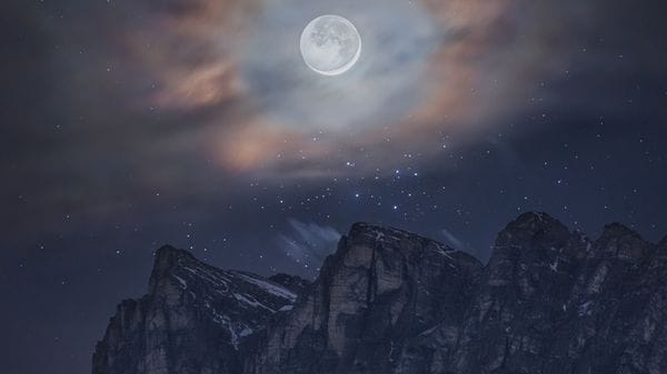 Un'aureola di nuvole per la Luna sopra le cime delle Dolomiti
