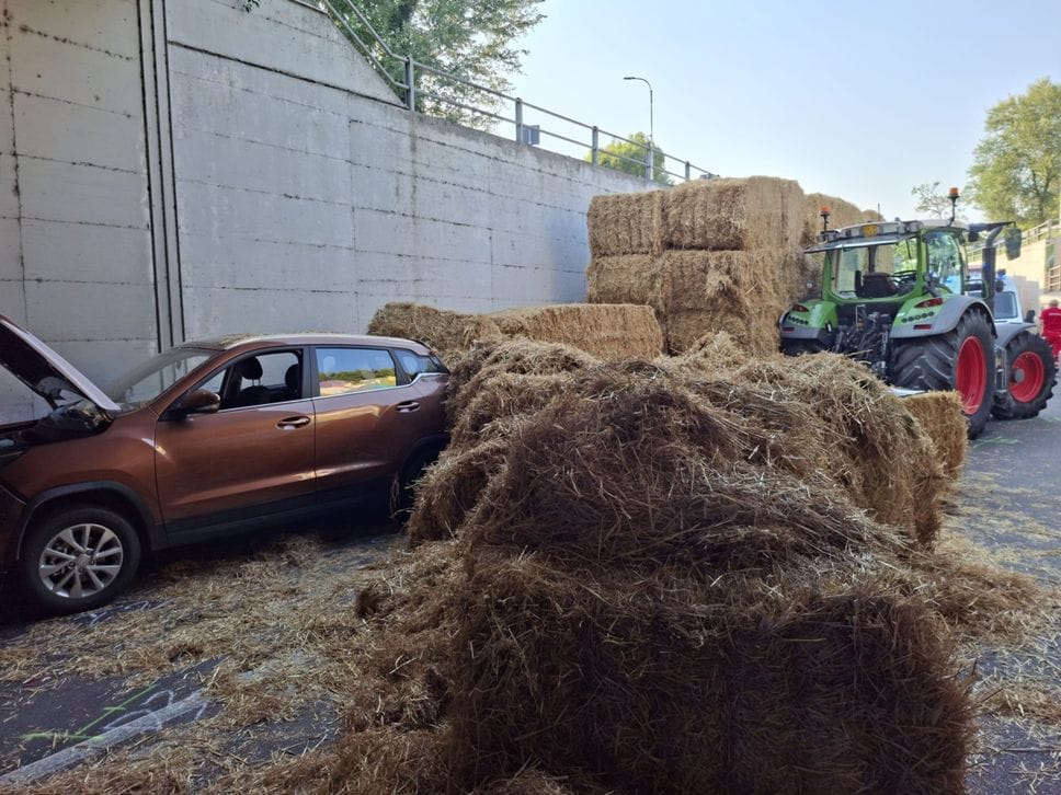 Trattore sterza e rovescia le balle di fieno su due auto e due moto a Romano -Foto